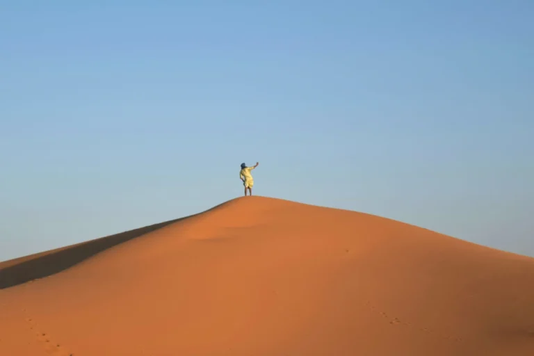 man taking a selfie from a sand dune during a sahara desert tour morocco