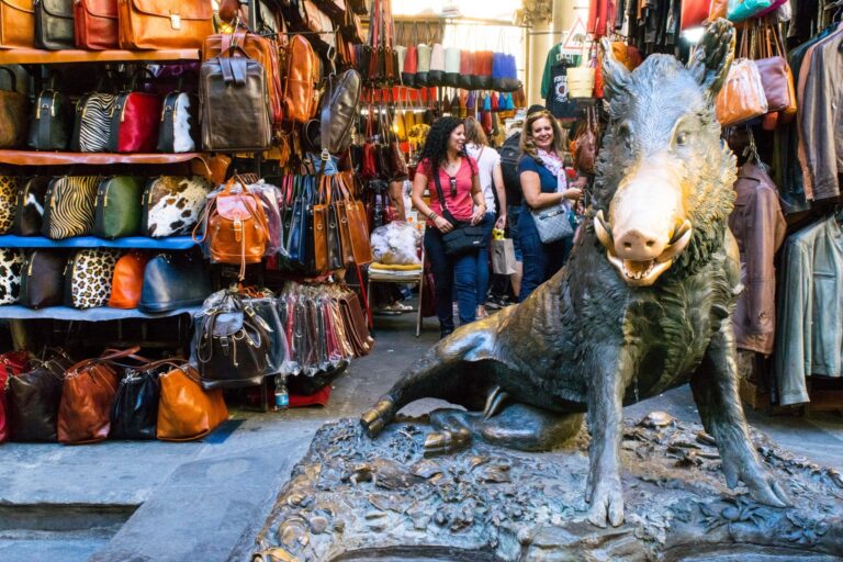 porcellino statue in front of mercato nuovo showing leather goods for sale, some of the top souvenirs from florence italy