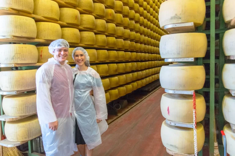 kate storm and jeremy storm touring a parmigiano reggiano factory, one of the best day trips parma italy